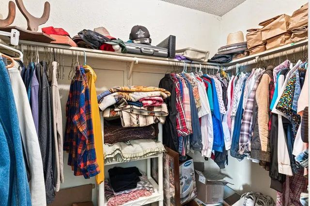 a view of walk in closet with clothes and shoes