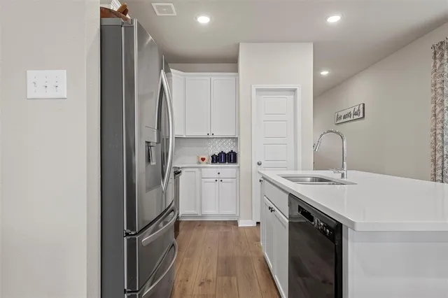 a kitchen with stainless steel appliances granite countertop a refrigerator and a stove top oven