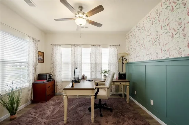 a view of a workspace with furniture and a window