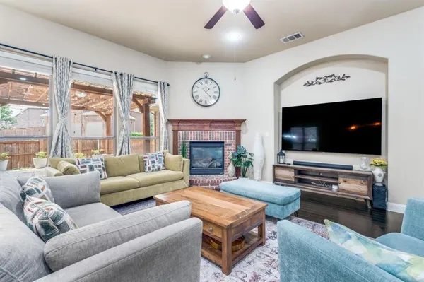 a living room with furniture a flat screen tv and a fireplace
