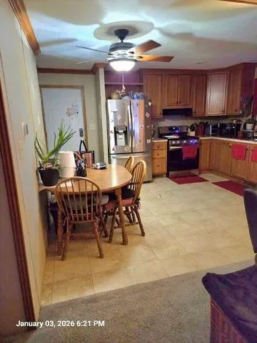 a kitchen with stainless steel appliances kitchen island granite countertop a table chairs sink and cabinets