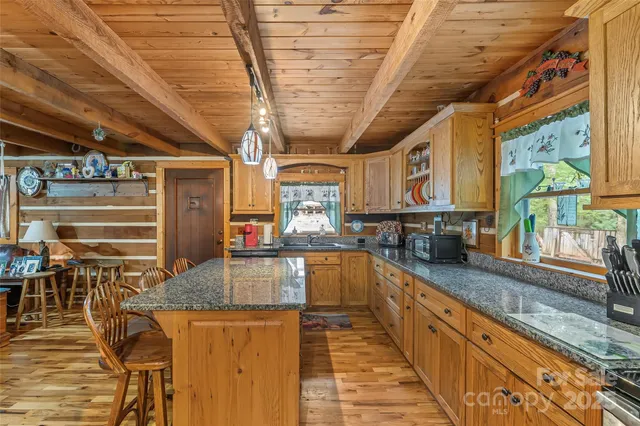 a kitchen with stainless steel appliances granite countertop a stove a sink and a wooden cabinets