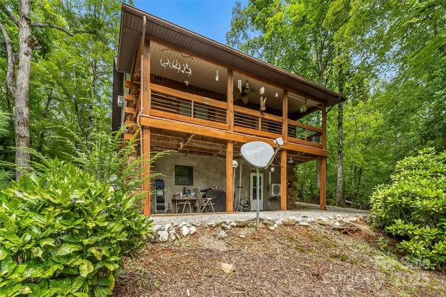 a view of a house with a porch and a large tree