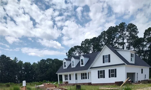 a front view of a house with a garden and trees