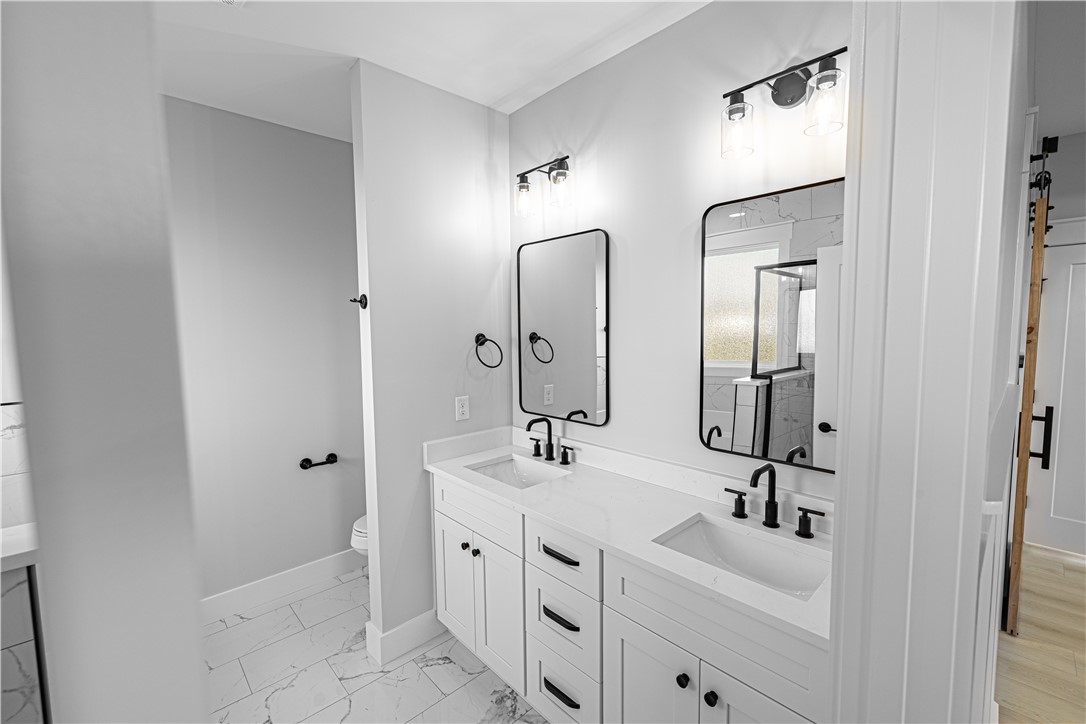 1296 Hebron Church Road Iva, SC 29655 - Photo 12 of 37 This bathroom features a double vanity with ample storage, sleek black fixtures, and modern mirrors.