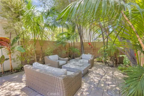 a view of a patio with couches and table and chairs under an umbrella