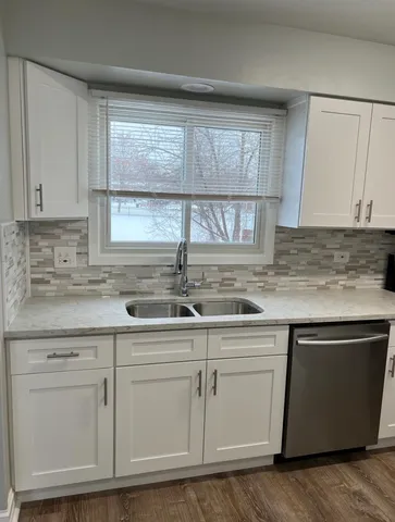 a kitchen with white cabinets and sink