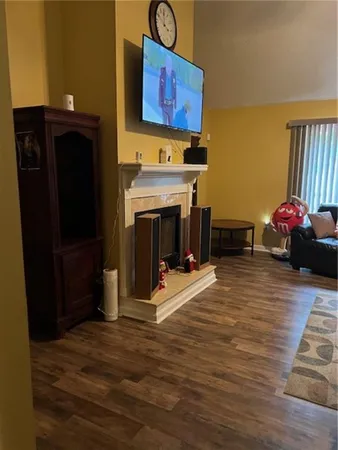 a view of a room with wooden floor and furniture