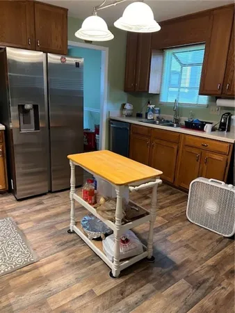a kitchen with stainless steel appliances wooden cabinets a stove a sink and a refrigerator