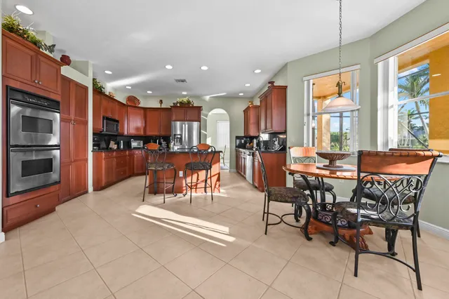 a kitchen with stainless steel appliances granite countertop stove top oven and cabinets