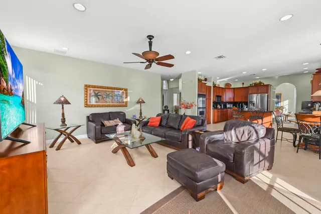 a spacious bedroom with a large bed and a chandelier fan