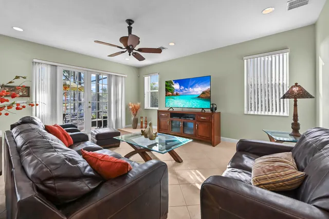 a spacious bedroom with a large bed and a chandelier fan