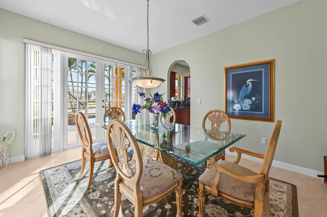 a dining area with stainless steel appliances kitchen island granite countertop a table chairs and a refrigerator