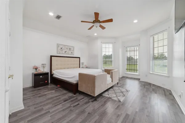 a bedroom with a bed and wooden floor