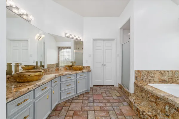 a spacious bathroom with a granite countertop sink a mirror and a