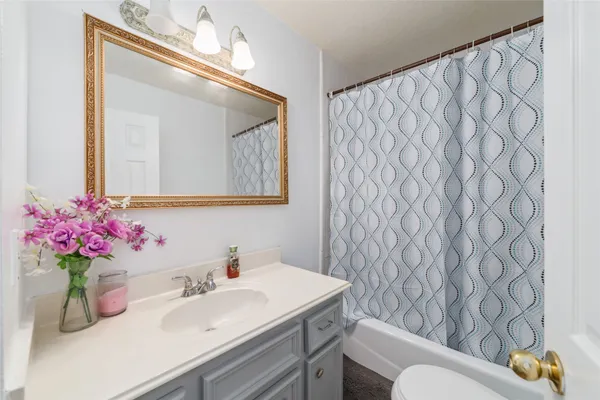 a bathroom with a sink vanity mirror and toilet