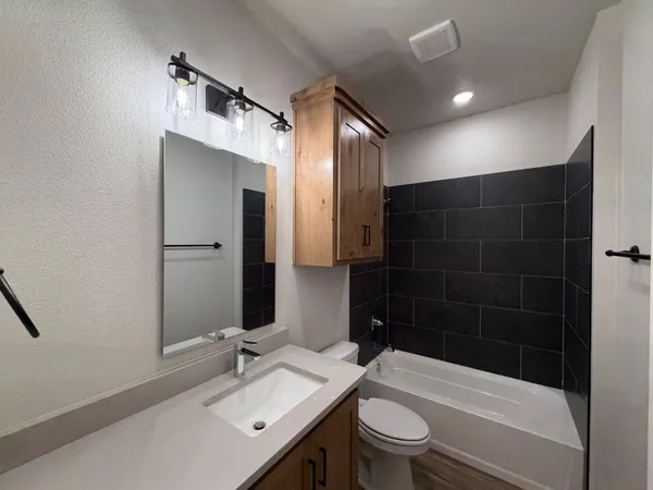 a bathroom with a sink a toilet and shower