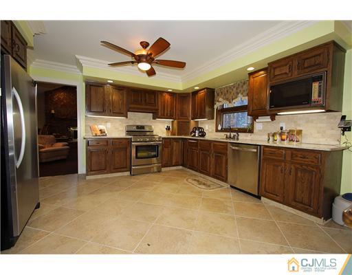 32 South Rhoda Street Monroe Township, NJ 08831 - Photo 8 of 20 a kitchen with stainless steel appliances granite countertop a stove top oven a sink and a refrigerator