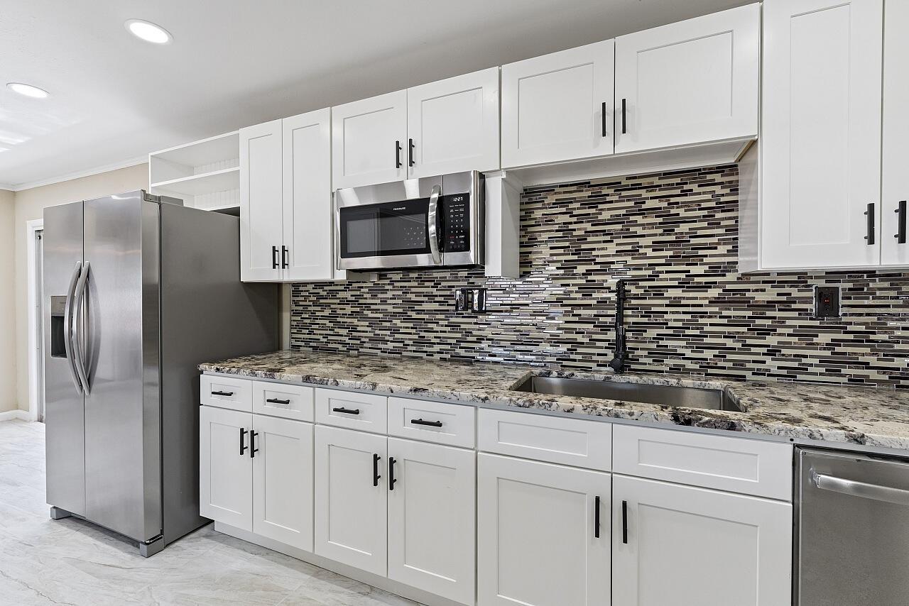 111 Alameda Avenue Sebastian, FL 32958 - Photo 11 of 33 a kitchen with a sink stainless steel appliances and white cabinets