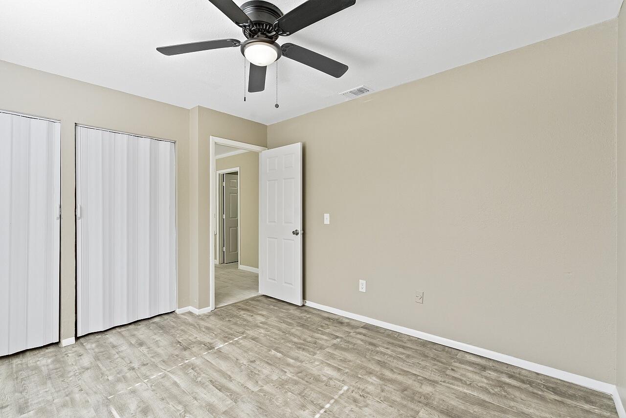 111 Alameda Avenue Sebastian, FL 32958 - Photo 23 of 33 an empty room with a ceiling fan and carpet