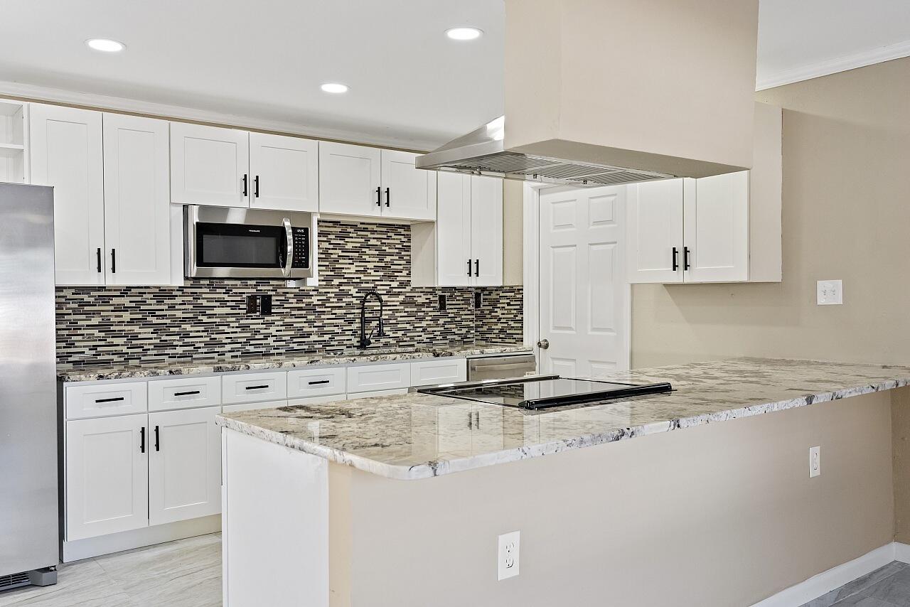 111 Alameda Avenue Sebastian, FL 32958 - Photo 8 of 33 a kitchen with granite countertop a sink a stove and cabinets