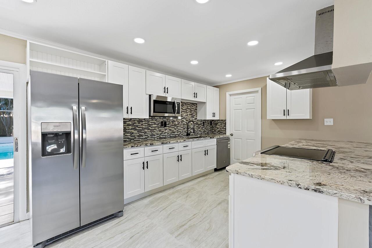 111 Alameda Avenue Sebastian, FL 32958 - Photo 9 of 33 a kitchen with stainless steel appliances granite countertop a refrigerator a sink a stove a microwave and island