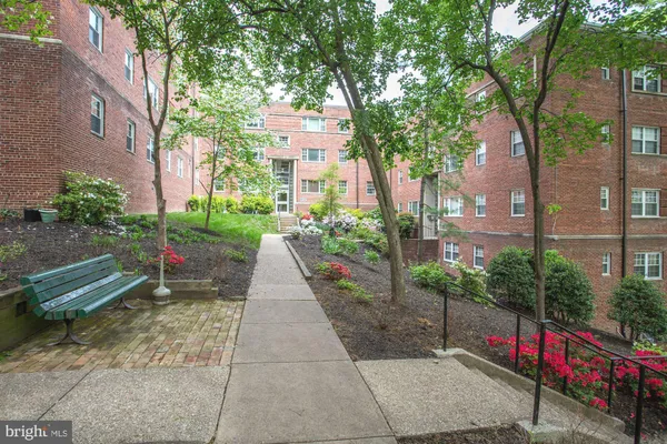 a backyard of a house with lots of green space fountain and large trees