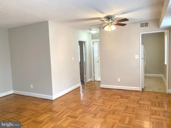 a view of a big room with wooden floor and a ceiling fan