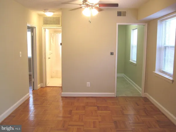 a view of an empty room with window and bathroom