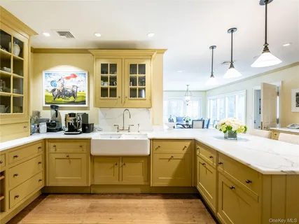 a dining hall with stainless steel appliances kitchen island granite countertop a stove a sink a dining table and chairs with wooden floor