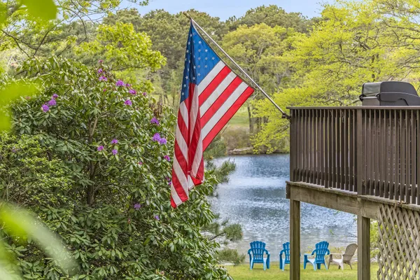 a front view of a house with a garden and trees