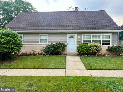 a front view of a house with a garden and yard