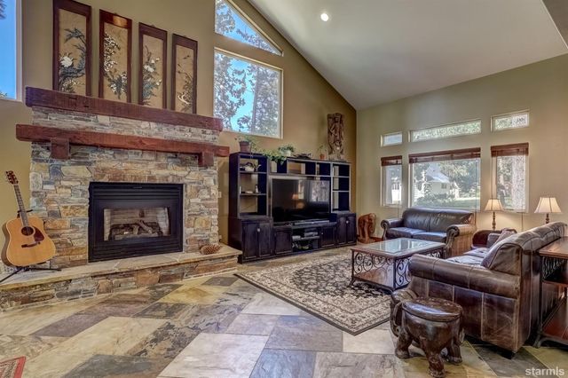 a living room with furniture a fireplace and a flat screen tv