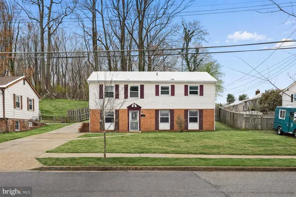 a view of a house with a big yard and large trees