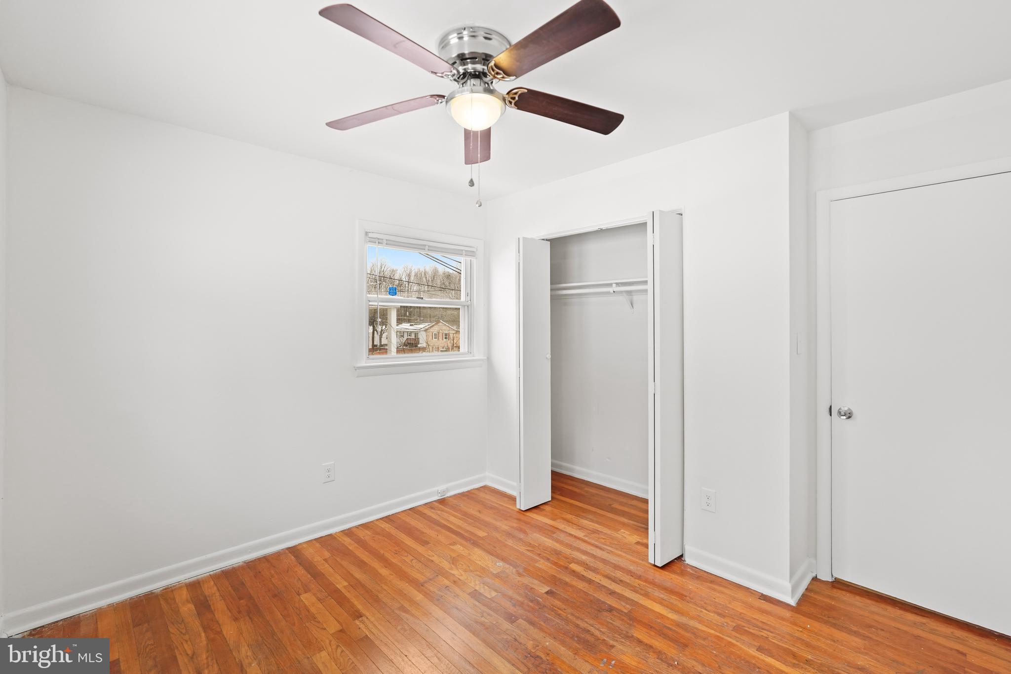 6903 Fawncrest Drive Capitol Heights, MD 20743 - Photo 27 of 36 an empty room with wooden floor ceiling fan and windows