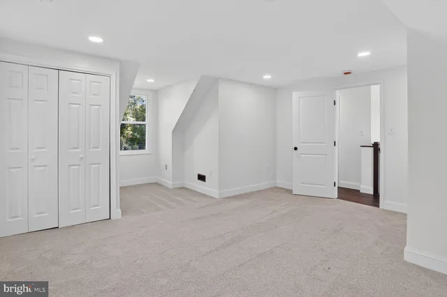 an empty room with windows and closet