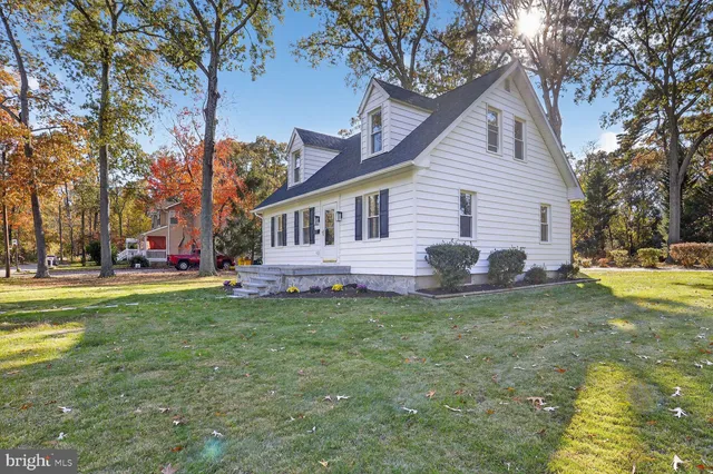 a view of a house with a big yard and large trees