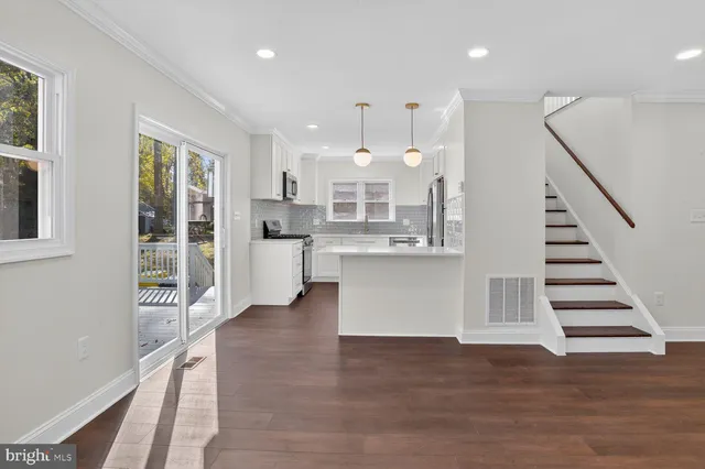 a view of a kitchen with wooden floor and electronic appliances