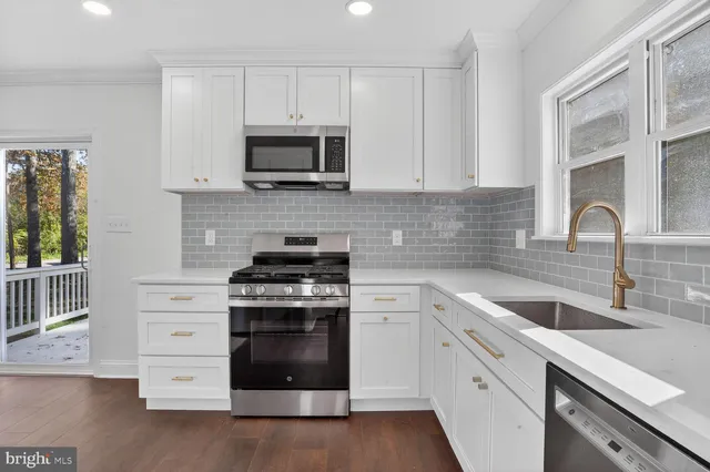 a kitchen with white cabinets and stainless steel appliances