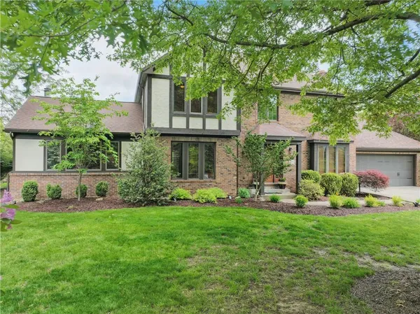 a front view of a house with a garden and yard