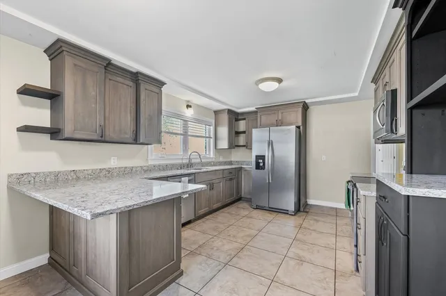 a kitchen with stainless steel appliances granite countertop a sink stove and refrigerator