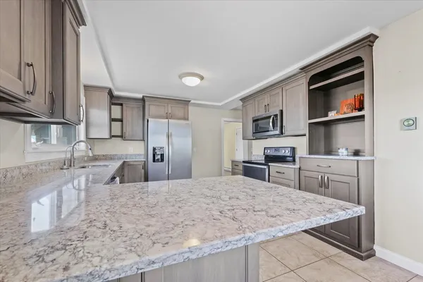 a kitchen with stainless steel appliances granite countertop a sink stove and refrigerator