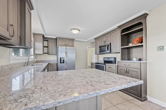 a kitchen with stainless steel appliances granite countertop a sink stove and refrigerator