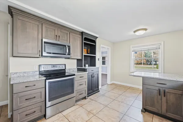 a kitchen with stainless steel appliances granite countertop a stove top oven microwave and cabinets