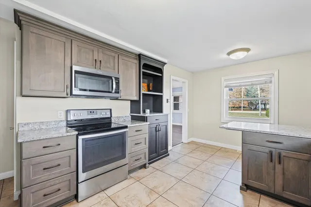 a kitchen with stainless steel appliances granite countertop a stove top oven microwave and cabinets