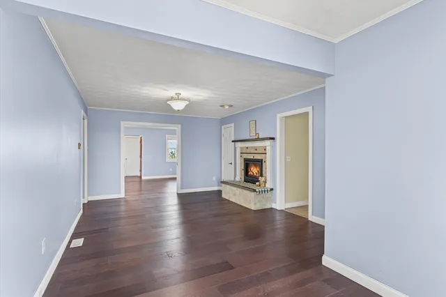 a view of a livingroom with wooden floor and a fireplace