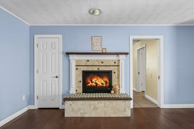 an empty room with fireplace and wooden floor