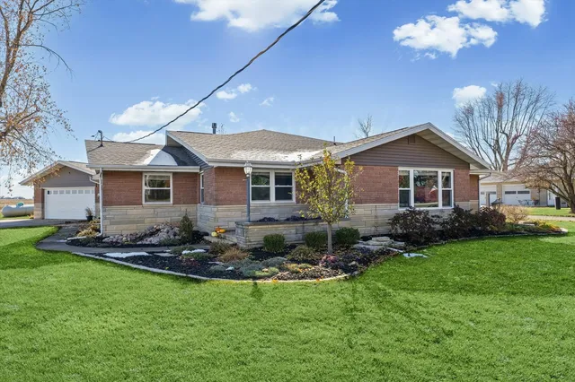 a front view of a house with a yard outdoor seating and garage