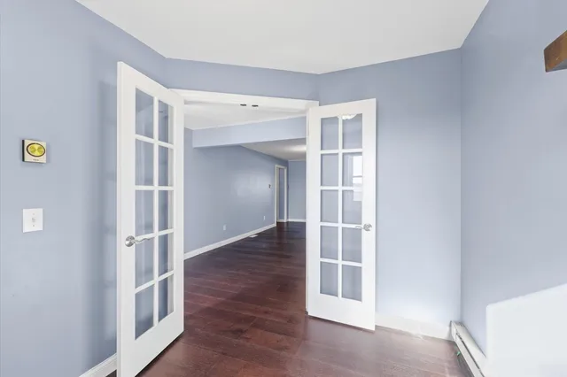 an empty room with windows and wooden floor