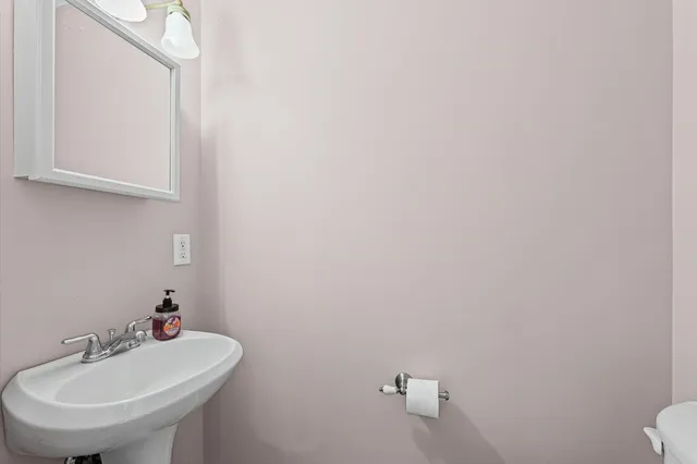 a bathroom with a sink a toilet and mirror